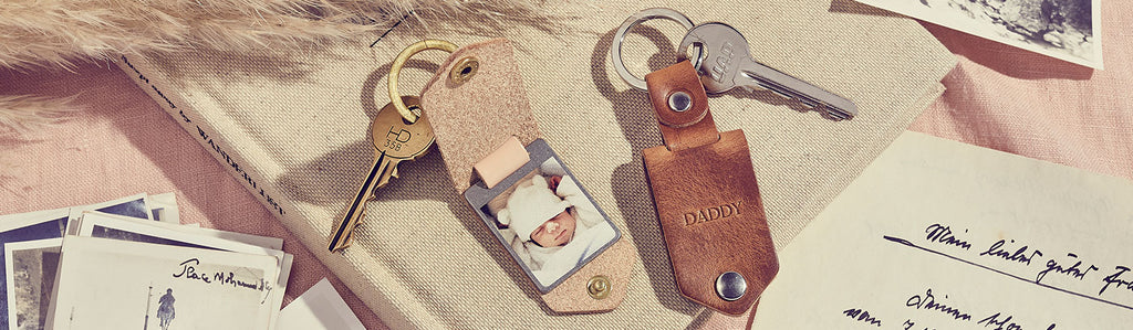 Pair of leather photo keyrings from Create Gift Love, shown with a scrapbook