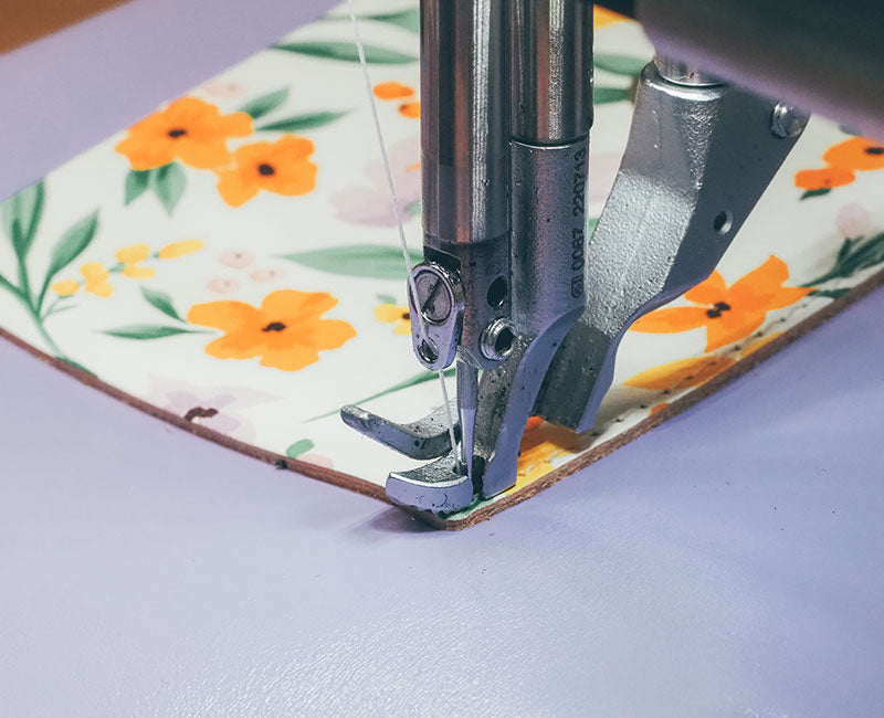 Lilac leather under a sewing machine printed with floral pattern