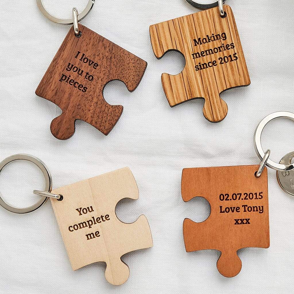 Four jigsaw shaped keyrings in various wood colours