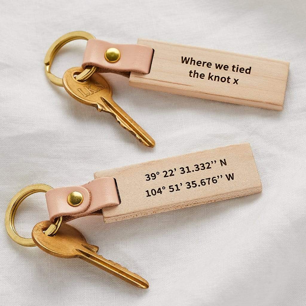 Wooden keyrings engraved with coordinates and the message 'where we tied the knot'