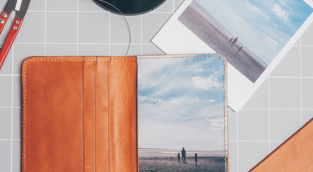 Brown leather wallet with a photo of a family on the beach printed inside