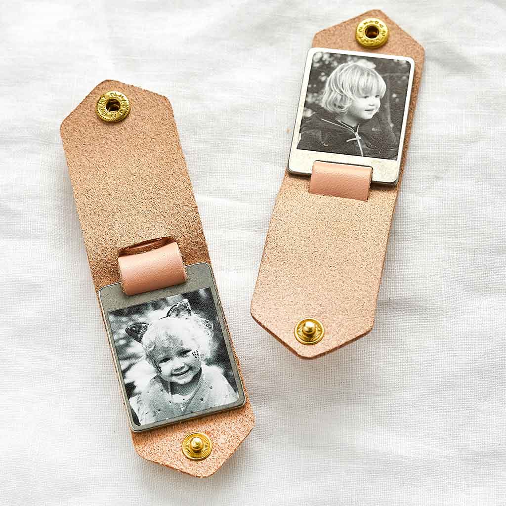 Two pink leather keyrings with children's photos insides
