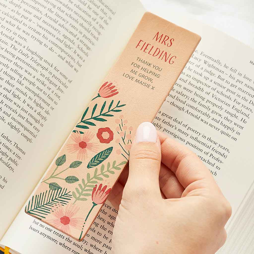 Bookmark printed with floral pattern, personalised with the message 'Mrs Fielding - thank you for helping me grow, love Maisie x' -- shown with a book