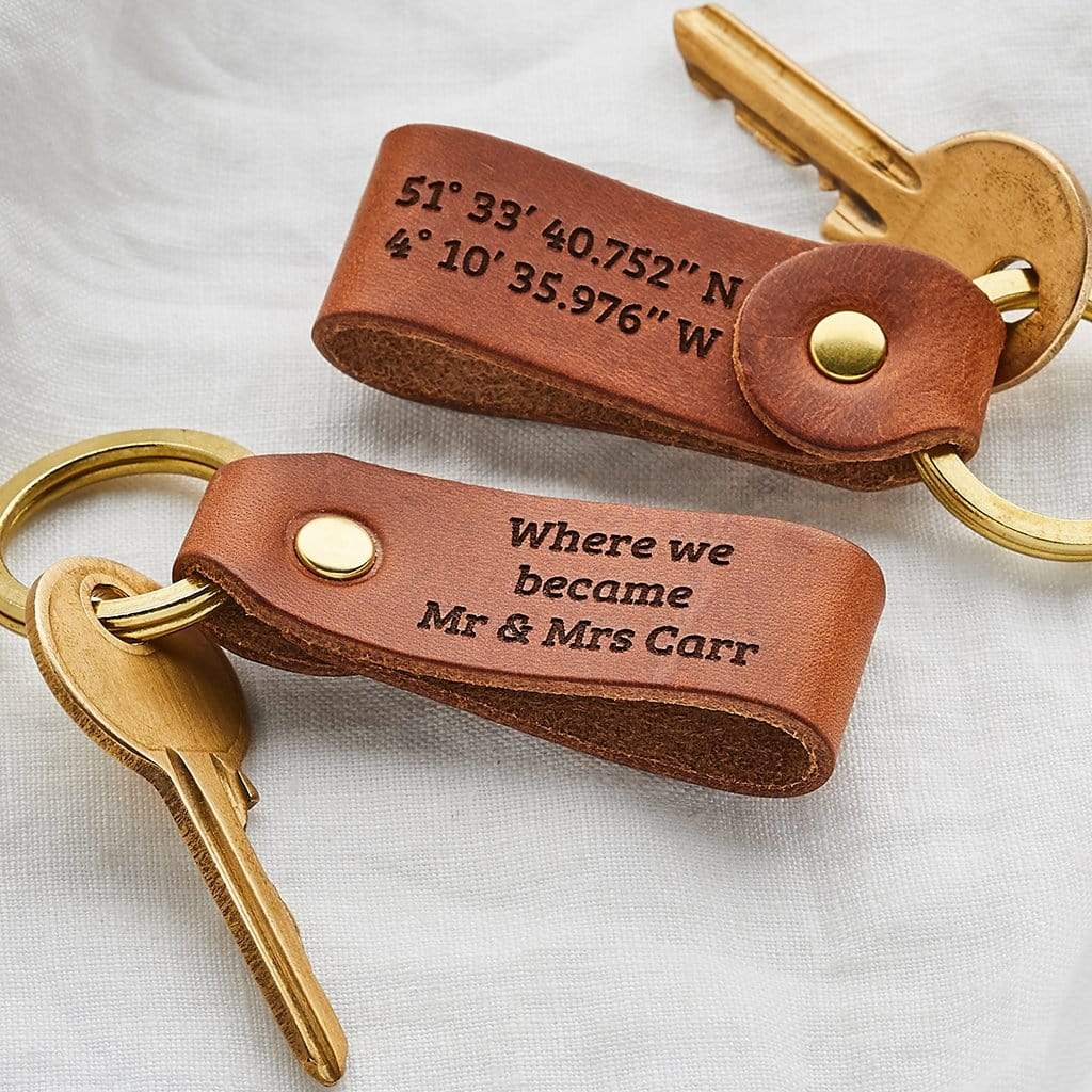 Pair of leather keyrings engraved with coordinates and the message 'where we became Mr & Mrs Carr'