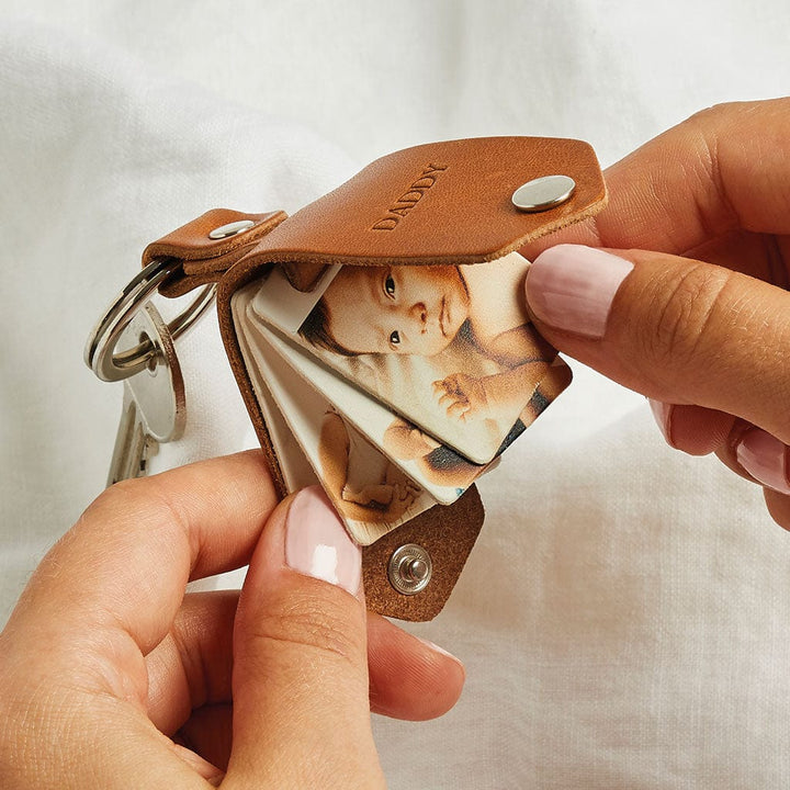 Brown leather keyring with four family photos inside