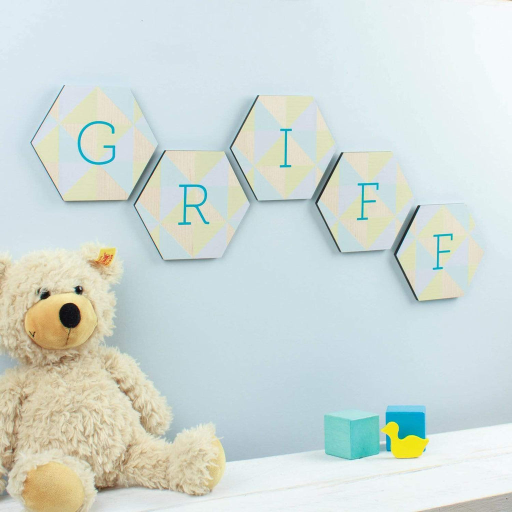 Hexagon shaped letter signs for a child's nursery; the example reads 'Griff' and is shown with a teddy bear and blocks