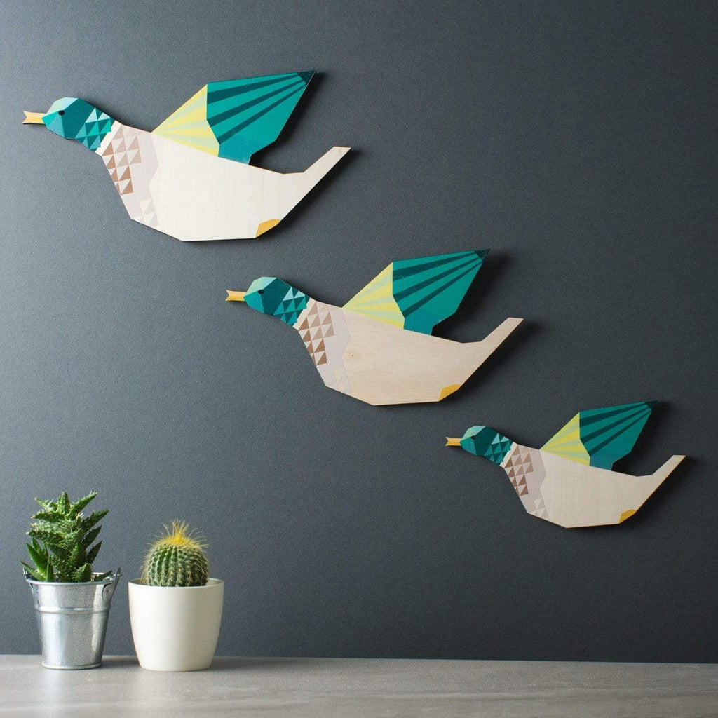 Set of three wooden ducks hanging on a wall